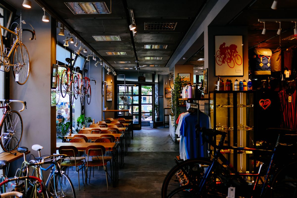 A welcoming bicycle shop and café with warm wood tables and bikes on display